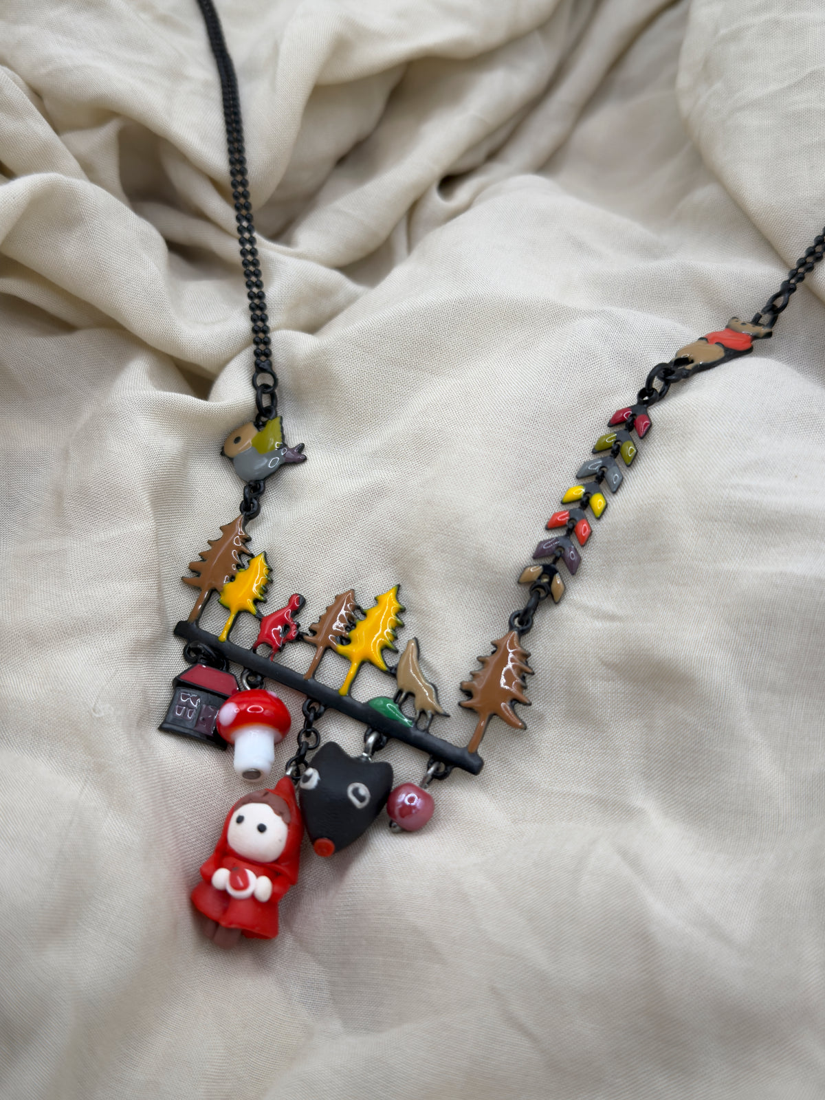 Collar "Cira" - Collar con diseño inspirado en La Caperucita Roja, con abalorios que cuentan la historia bajo un denso bosque